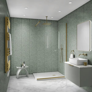 A modern bathroom interior with green textured wall panels, a white marble-look floor, a walk-in shower area with a glass door and gold-toned fixtures, a white vessel sink with a matching vanity, and a gold towel radiator.