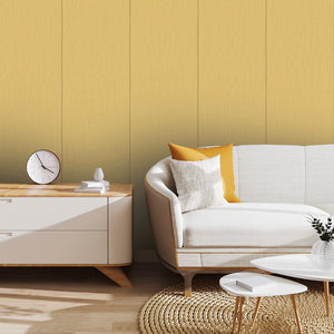 A styled living room corner featuring a white sofa with yellow and white pillows, a light wood sideboard with a round clock, and a textured mustard-yellow paneled wall.