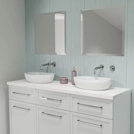 Bathroom vanity with two white sinks, mirrors, and decorative items on a light blue wall.