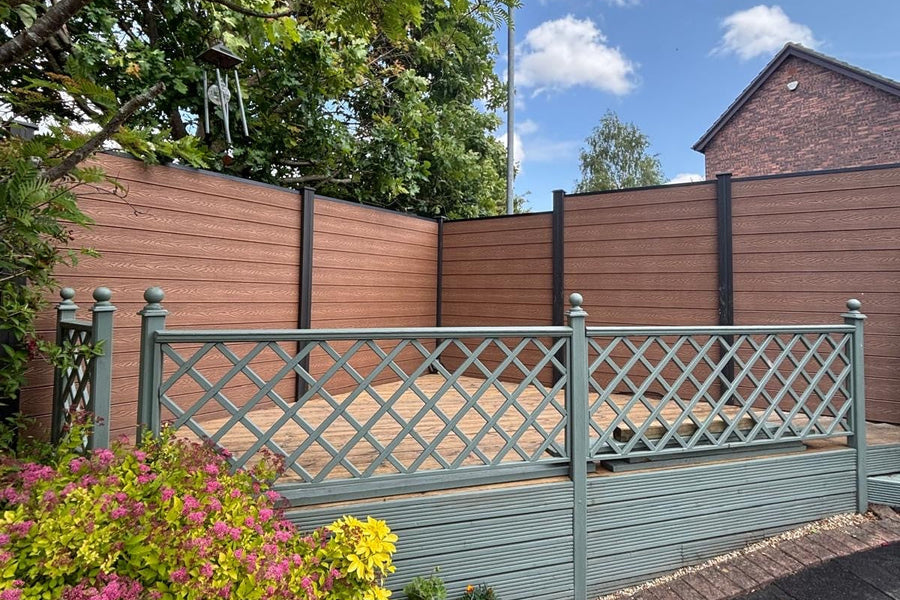 Garden with a wooden fence, plants, and a clear blue sky.
