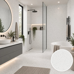 A modern bathroom interior featuring white speckled floor and wall tiles, a glass shower enclosure, a white freestanding tub, a gray floating vanity, and a circular inset showing a close-up of the tile texture.