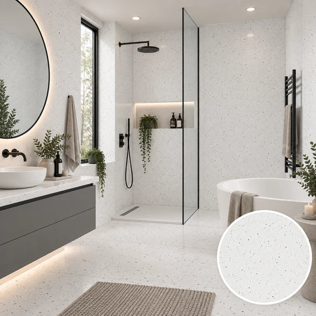 A modern bathroom interior featuring white speckled floor and wall tiles, a glass shower enclosure, a white freestanding tub, a gray floating vanity, and a circular inset showing a close-up of the tile texture.