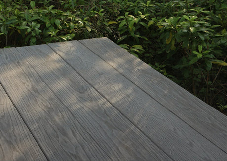 Grey Oak TimbeX XL composite decking installed beside a planted garden border