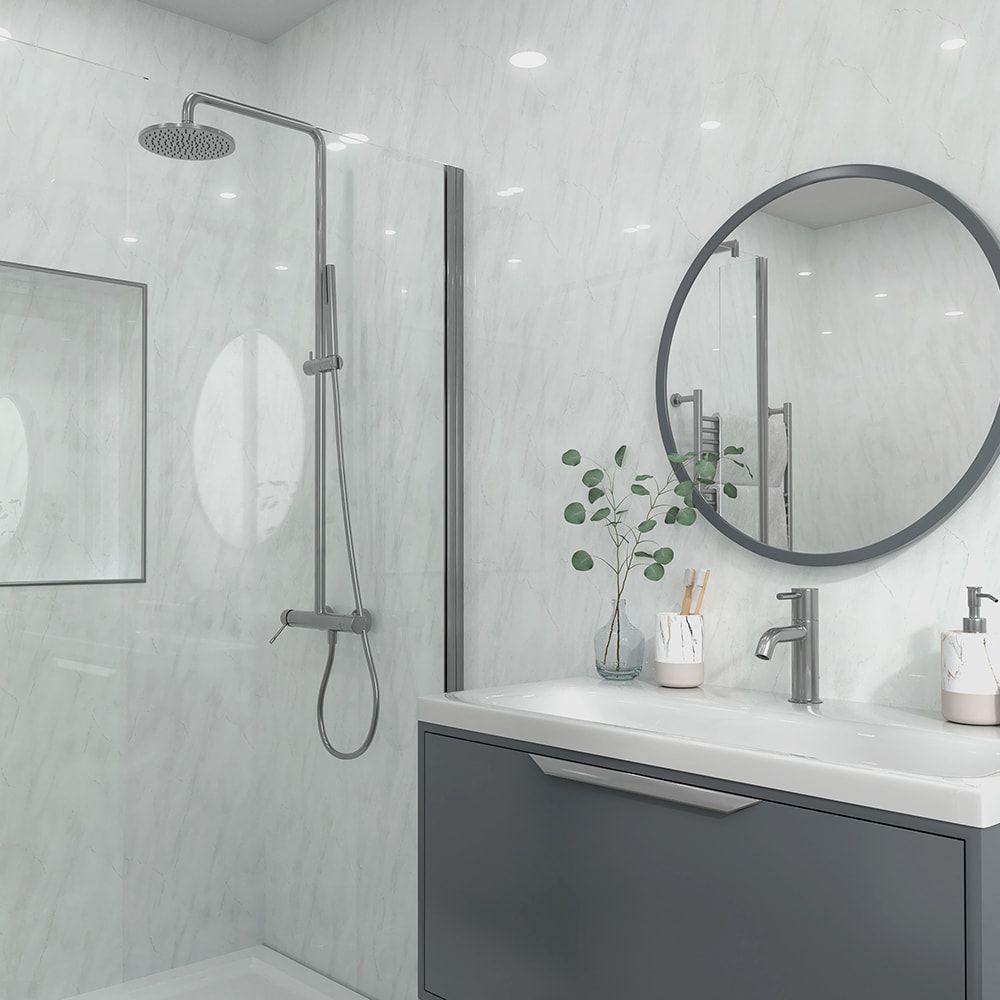Modern bathroom interior featuring a walk-in shower area with a matte gray shower fixture, a white countertop, a dark gray vanity, a round black-framed mirror, and light marble-look wall tiles.