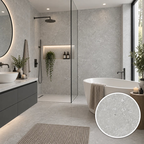 A modern bathroom interior with light gray stone-look tiles, a freestanding white bathtub with a draped beige towel, a glass shower enclosure, a dark floating vanity, and a circular inset showing a close-up of the tile texture.